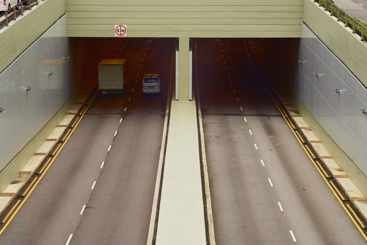 Services Aerial view of a highway tunnel with minimal traffic and clear lanes.